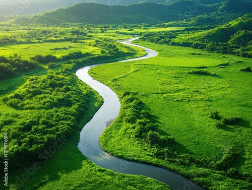 Breathtaking aerial view of a winding river surrounded by lush green fields and mountains, showcasing the beauty of nature.