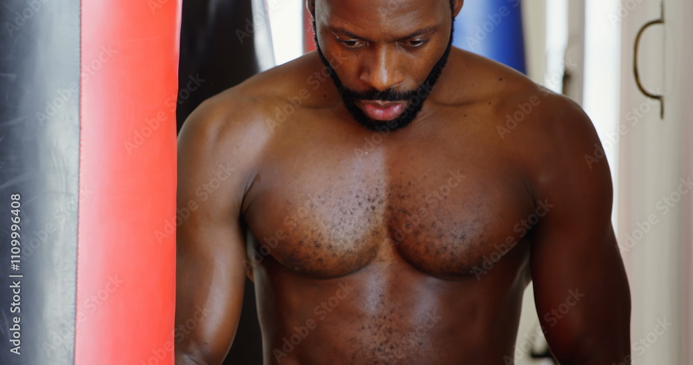 Focused male boxer practicing boxing in fitness studio Focused male boxer practicing boxing in fitness studio