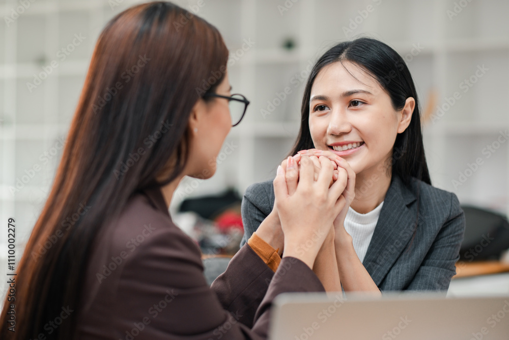 Two businesswomen in a modern office, sharing a supportive moment, highlighting teamwork and professional relationships. Two businesswomen in a modern office, sharing a supportive moment, highlighting teamwork and professional relationships.