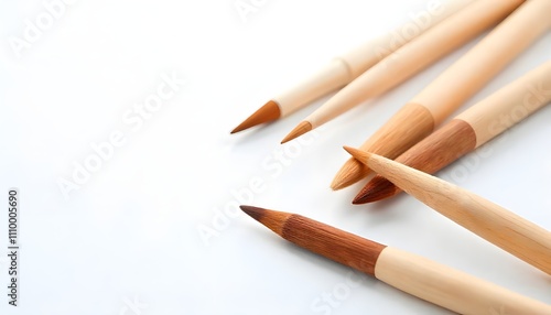 A set of three wooden brown paint brushes, neatly arranged and isolated on a white background, representing essential tools for artists and painters, ideal for canvas work