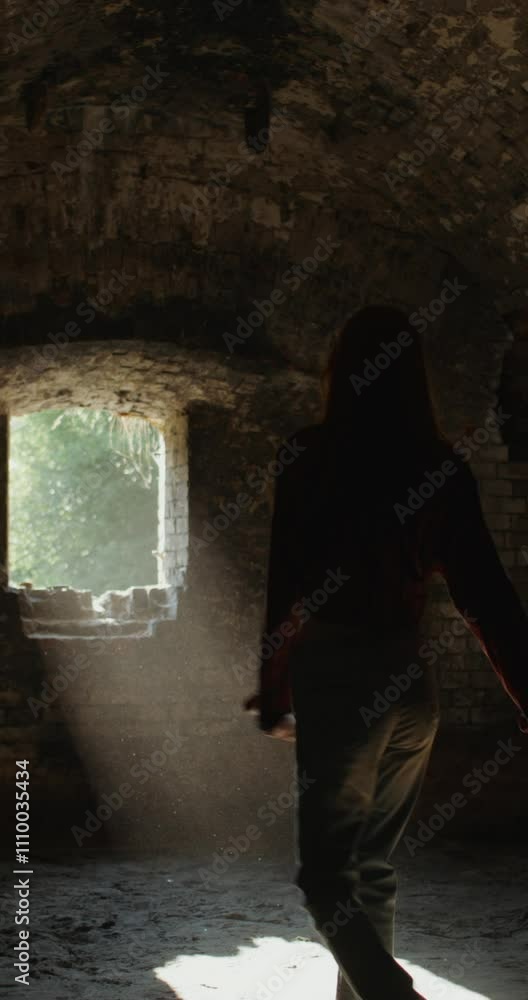 Three friends smile and talk as they walk around a room in a historic abandoned brick building. Sunlight in the window Three friends smile and talk as they walk around a room in a historic abandoned brick building. Sunlight in the window