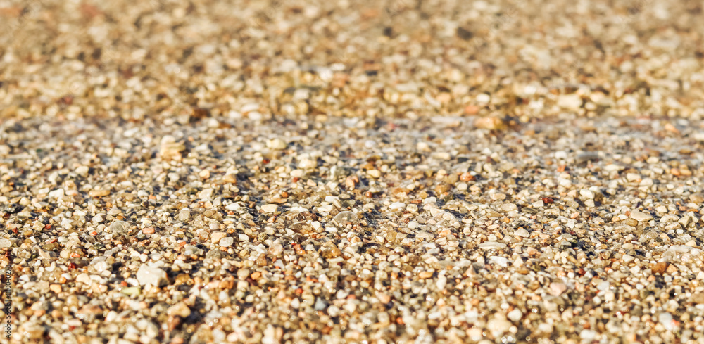 Background of sand, small pebbles and flowing wave on the sea beach. Summer vacation concept Background of sand, small pebbles and flowing wave on the sea beach. Summer vacation concept