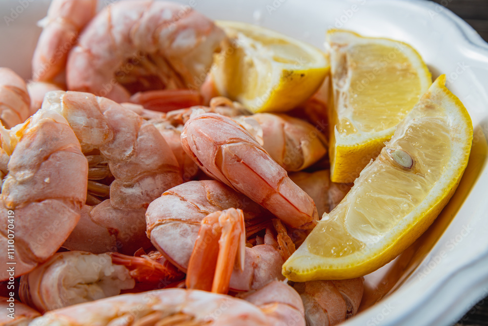 Boiled king prawns in a deep bowl with lemon, close up view Boiled king prawns in a deep bowl with lemon, close up view