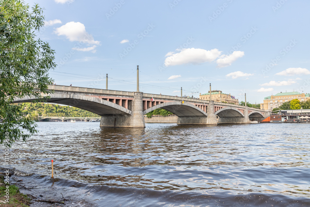 Fototapeta premium View from embankment of the Manes Bridge and the opposite embankment on Vltava River in Prague in Czech Republic