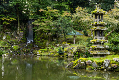 Japanese garden with waterfall and lantern.