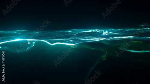 Seamless loop video of bioluminescent water with a slow pan and neon lighting. dark background emphasizes the natural light emission