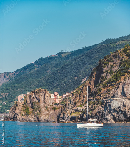 coast of Riomaggiore with a sailboat in Cinque Terre