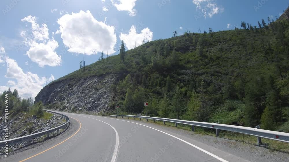 Driving in a car along the mountain road of the Chuya Highway or the Chuysky Trakt over mountain pass Chike-Taman in Altai. Driving in a car along the mountain road of the Chuya Highway or the Chuysky Trakt over mountain pass Chike-Taman in Altai.