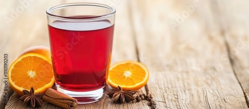 Mulled wine in a glass with spices and fresh orange slices on a rustic wooden table setting photo