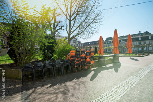 A closed terrace in Haguenau, France, during the COVID pandemic, featuring neatly arranged chairs and warm light creating a serene, atmospheric scene photo