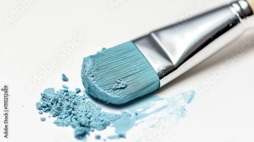 Aquamarine paintbrush with a smear and powder on a white background showcasing artistic creativity and color texture. photo