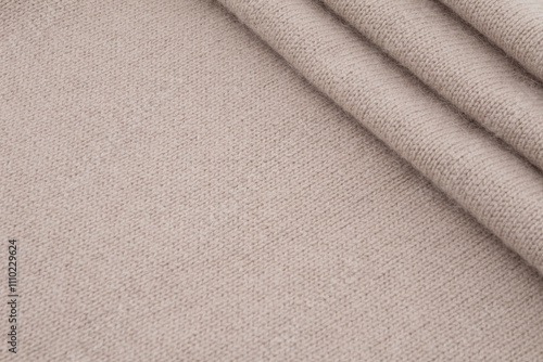 Fotografía Folded beige woolen knitted fabric texture background