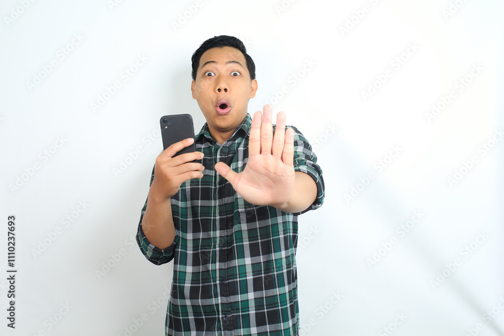 stop gesture, surprised asian man holding smartphone and show forbidden signs isolated on white background stop gesture, surprised asian man holding smartphone and show forbidden signs isolated on white background