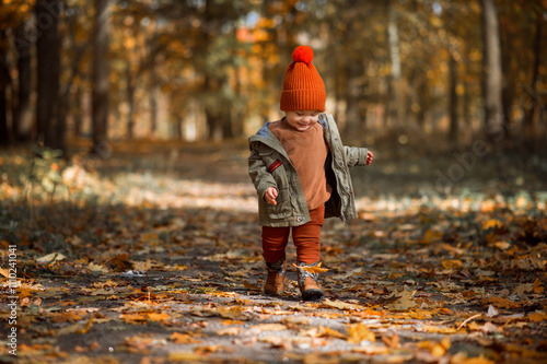 Cute baby in autumn clothes looks. ?hild in knitted hats and jacket in cool weather. photo