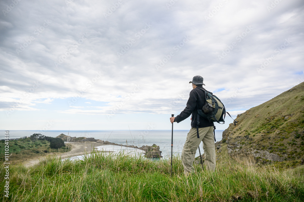 Man hiking the Deliverance Cove track. Castlepoint. Wairarapa. New Zealand.