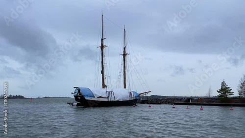 A Sailing Ship Gliding Smoothly on Calm Waters Beneath Overcast, Cloudy Skies Above