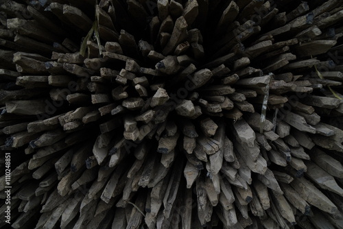 A dense, chaotic arrangement of wooden sticks, creating a dark and textured background.