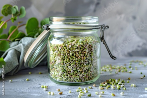 Raw green buckwheat sprouted cereals, green buck wheat grains in jar, uncooked kasha sprouts heap photo