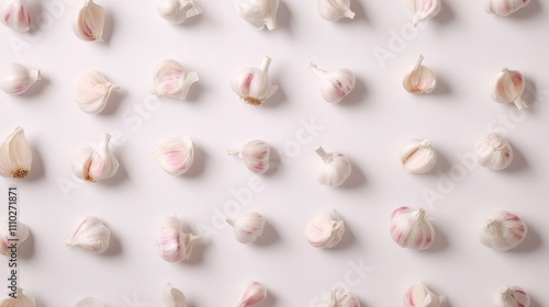 Fresh garlic cloves arranged artistically on a clean white background highlighting texture and natural colors for culinary use.