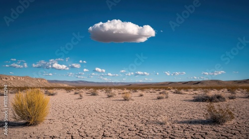 Unique desert landscape featuring a solitary cloud in a vast blue sky during daylight hours