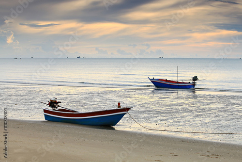 Fishing boat in sunrise background at Pranburi beach, Prachuap Khiri Khan Province, Thailand 