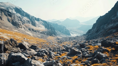 Rugged mountain valley with rocky terrain and distant peaks at sunrise in a remote wilderness setting