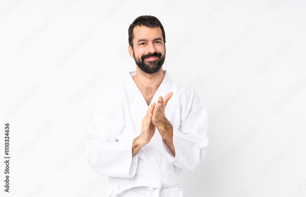 Young man doing karate over isolated white background applauding after presentation in a conference Young man doing karate over isolated white background applauding after presentation in a conference