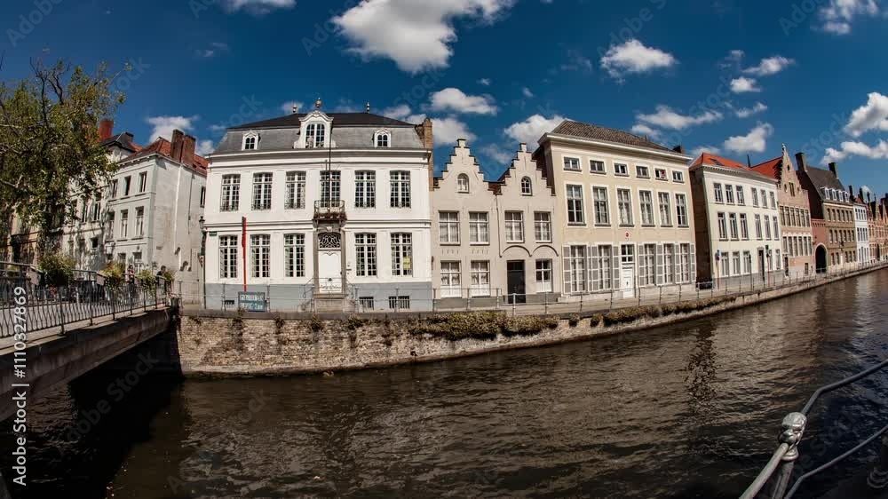 Must see places in Belgium : timelapse of Bruges Sint-Annarei water canal with tour boats and typical architecture. Europe top destination.