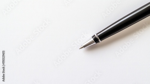 A Closeup Shot of a Sleek Black Ballpoint Pen on Pristine White Paper Ready for Writing or Note-Taking photo