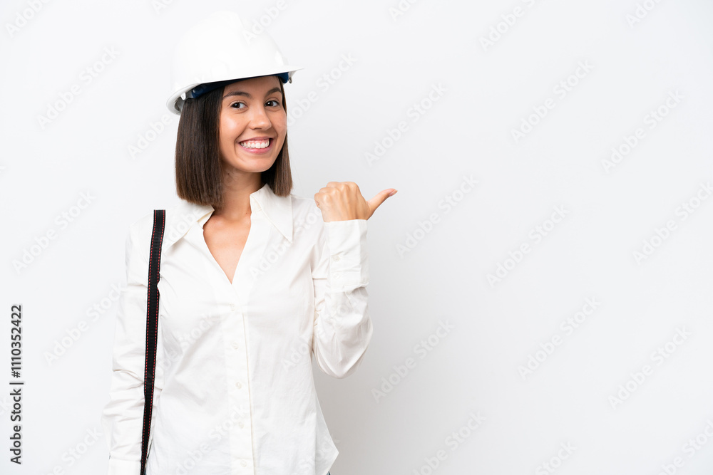 Young architect woman with helmet and holding blueprints isolated on white background pointing to the side to present a product Young architect woman with helmet and holding blueprints isolated on white background pointing to the side to present a product