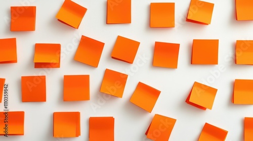 Playful arrangement of orange sticky notes on a stark white backdrop, symbolizing ideas and creativity