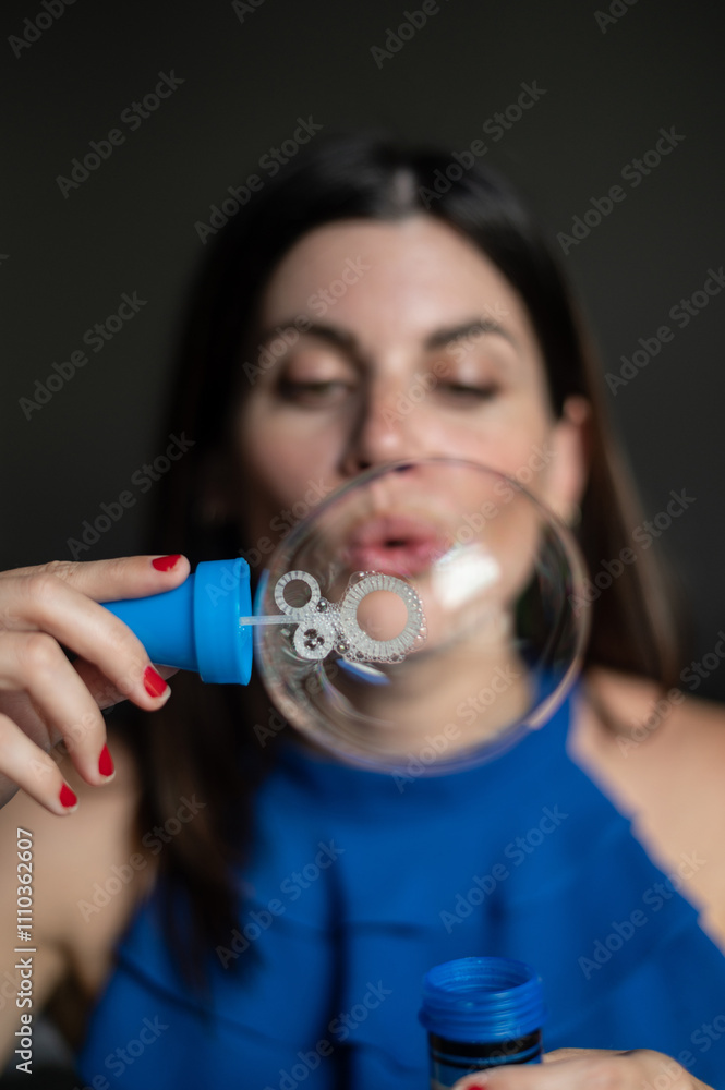 Interior portrait of an attractive caucasian woman in her thirties blowing soap bubbles Interior portrait of an attractive caucasian woman in her thirties blowing soap bubbles