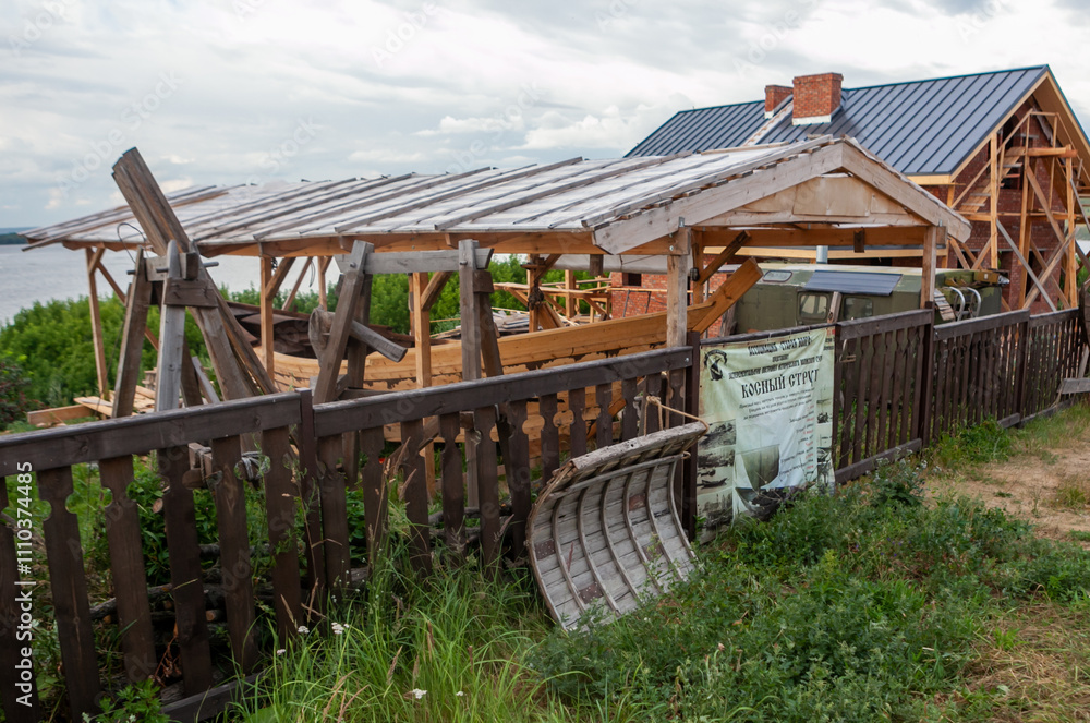 Obraz premium A rustic wooden building takes shape near the riverbanks of Sviyazhsk, showcasing local craftsmanship and charm.