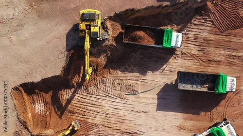 Aerial view road motor grader flatting dirt road surface, Motor grader road construction grader industrial machine construction site new road, Aerial view group excavator working on construction site.