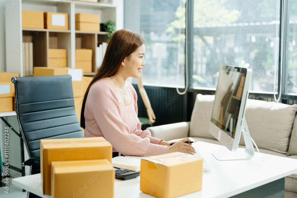 Young businesswoman managing online sales and shipping from a modern home office. Young businesswoman managing online sales and shipping from a modern home office.