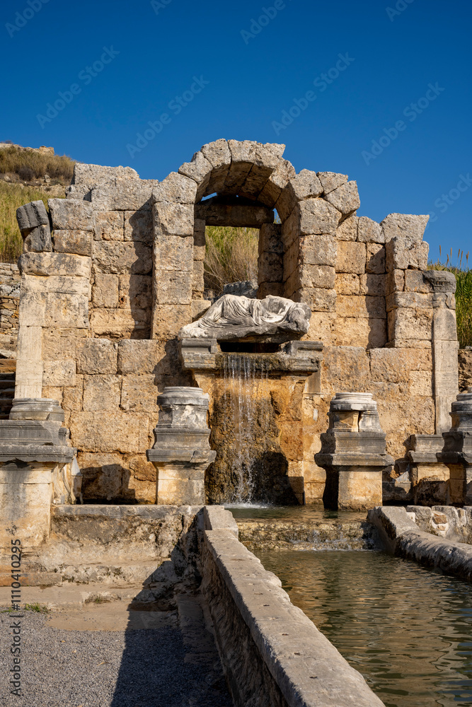 Naklejka premium Rows of columns in Perge, Antalya, Turkey. Remains of colonnaded street in Pamphylian ancient city.Rows of columns in Perge, Antalya, Turkey. Ancient Kestros Fountain. Aksu, Antalya