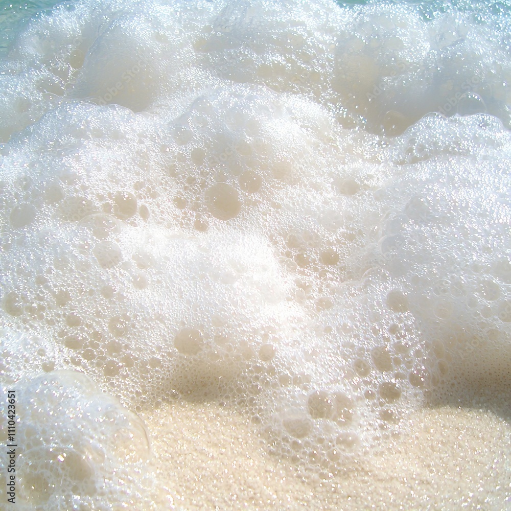 Close-up of white ocean foam on sandy beach. Close-up of white ocean foam on sandy beach.