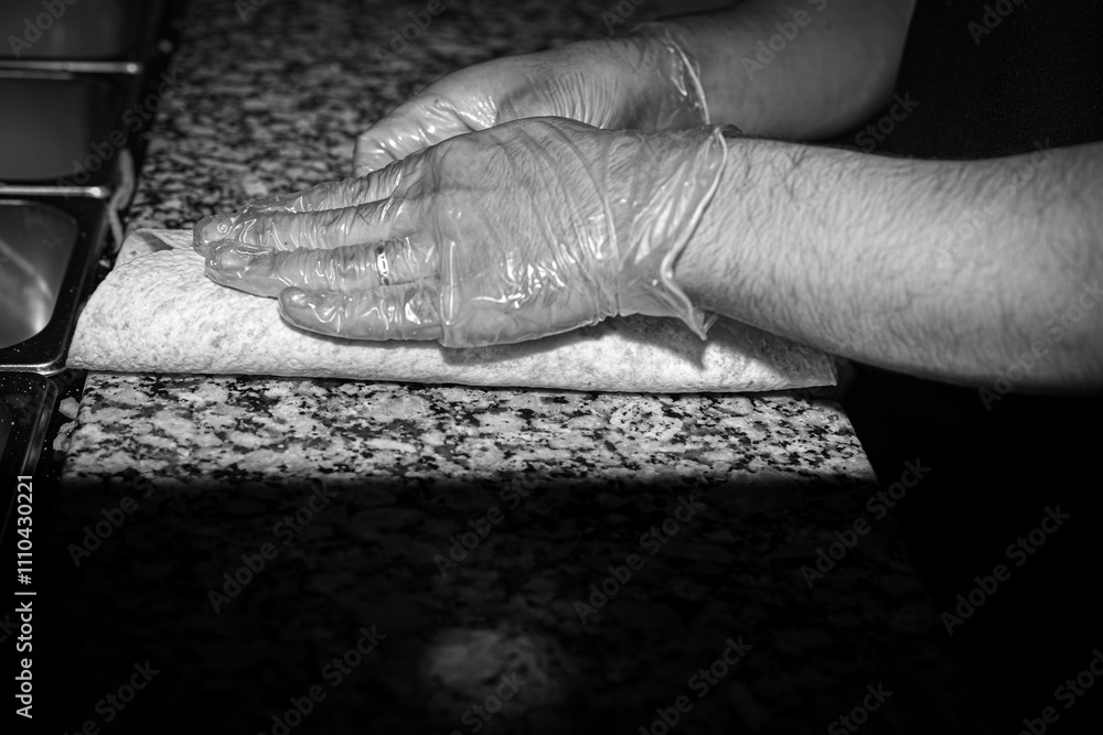 wrap preparation, black-and-white, culinary art, food hygiene, chef's hands, gloved hands, marble countertop, professional kitchen, food wrapping, texture, culinary process, kitchen work, clean enviro