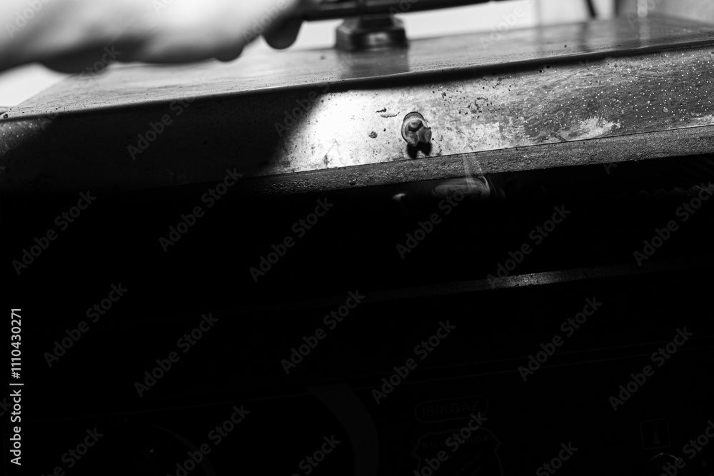 The heat is on as an industrial panini press flattens and cooks a wrap. The shot focuses on the textures of the grill and the warm, golden hue of the dough.