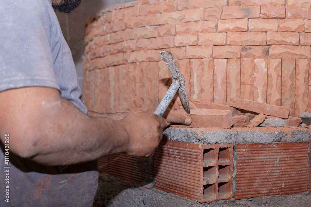 Close-up of hands working on bricks, highlighting the skill and precision of traditional masonry.