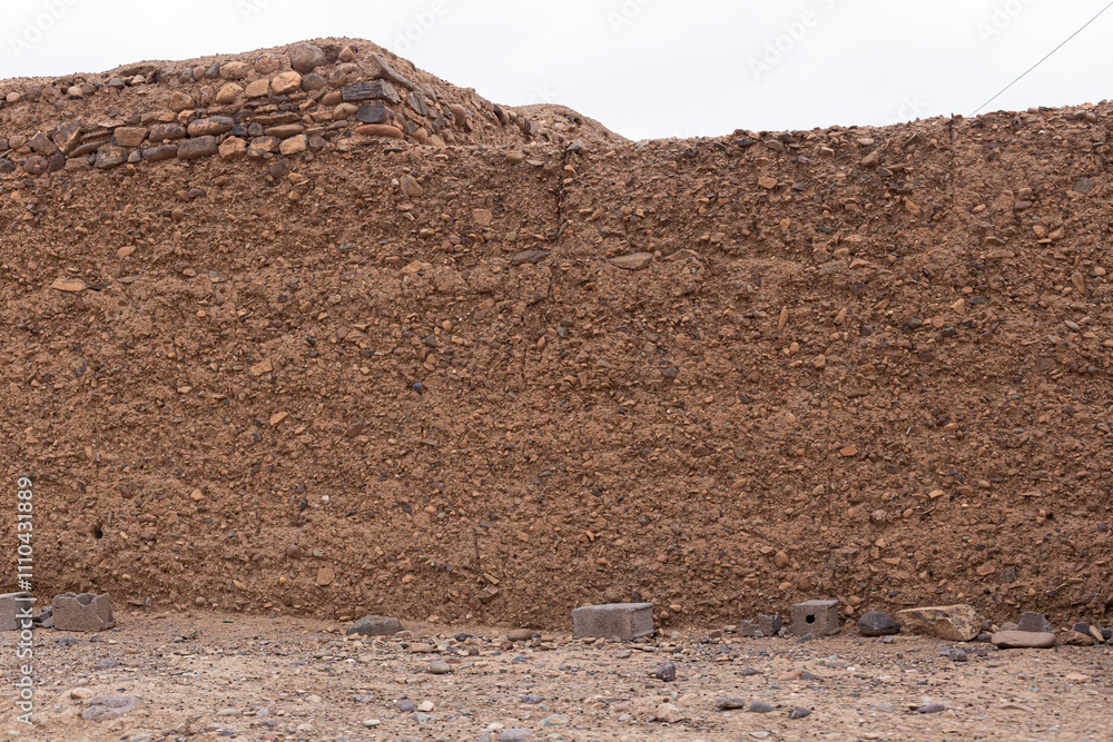 The earthy tones and irregular textures of this mud wall, built using age-old techniques, bring a sense of authenticity to the Moroccan countryside.
