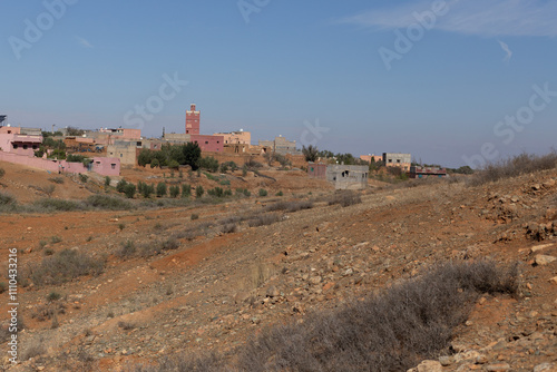 Obraz na płótnie A peaceful village in southern Morocco, with a mix of mudbrick and cement houses. The Atlas Mountains rise in the distance, w salonie