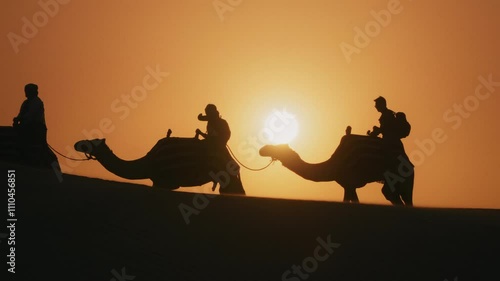 Wallpaper Mural Silhouette of tourists riding camels on top of a dune in a safari desert tour during sunset Torontodigital.ca