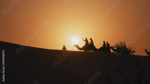 Wallpaper Mural Silhouette of tourists riding camels on top of a dune in a safari desert tour during sunset Torontodigital.ca