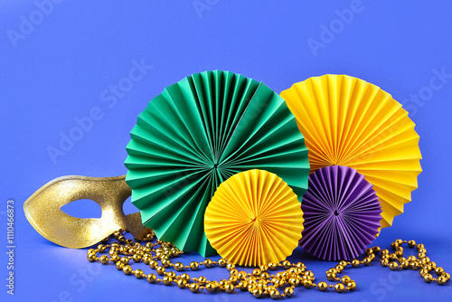 Colorful paper fans with carnival mask and beads on blue background. Celebration of Mardi Gras photo