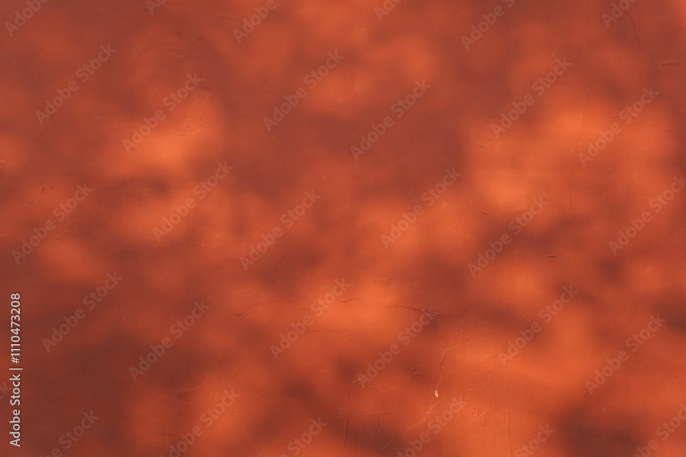 Faded red wall with shadow of leaves on it