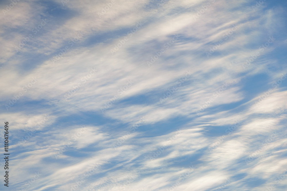 Soft white, semi-translucent clouds crowd the sky, leaving numerous spotted holes of various sizes where the light blue of the daylight sky is peaking through. Soft white, semi-translucent clouds crowd the sky, leaving numerous spotted holes of various sizes where the light blue of the daylight sky is peaking through.