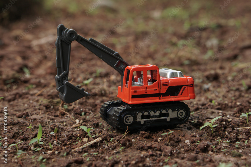 side view of Orange excavator or digger toy excavate on a soil land outdoor. model scale of digger photograph, construction concept. side view of Orange excavator or digger toy excavate on a soil land outdoor. model scale of digger photograph, construction concept.