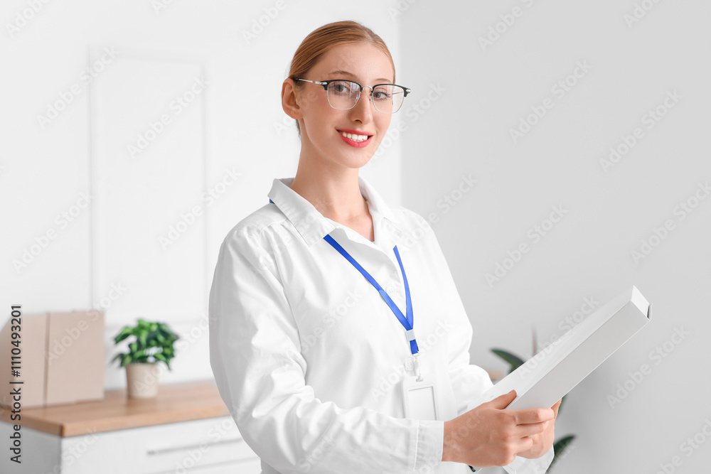 Happy female doctor with badge and folder in clinic Happy female doctor with badge and folder in clinic