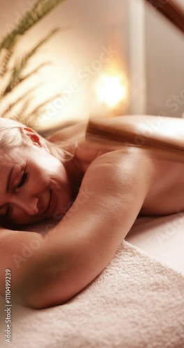 Mature woman receiving bamboo stick massage at spa - vertical video